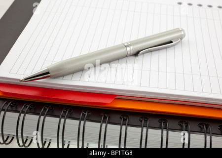 Silber, Stift und zwei Papier-Notebooks: Orange und schwarz Stockfoto