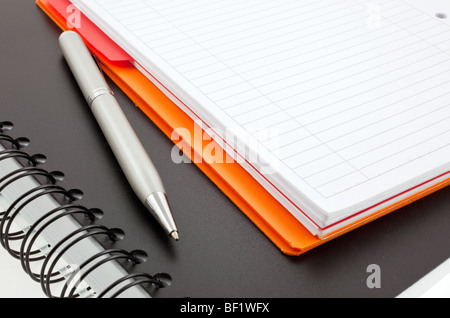 Silber, Stift und zwei Papier-Notebooks: Orange und schwarz Stockfoto