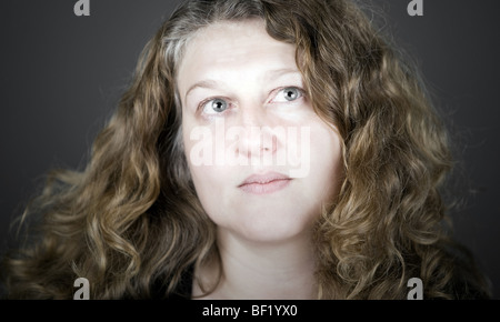 Schuss von einem mittleren Alter Frau mit langen lockigen Haaren Stockfoto