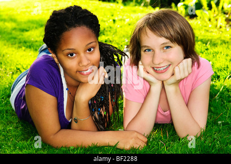 Zwei glückliche Mädchen im Teenageralter Verlegung auf Rasen Stockfoto