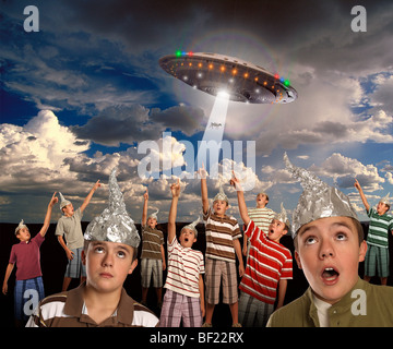 Eine Gruppe von Klonen mit Alufolie hüten verweist auf ein UFO entführt eine Kuh! Stockfoto