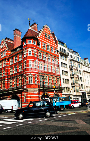 London Taxi auf belebten Straßenecke in England Stockfoto