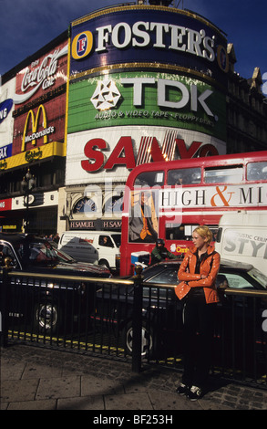 Mädchen mit orange Jacke am Piccadilly Circus, City of London. England, Vereinigtes Königreich, Großbritannien, Europa Stockfoto