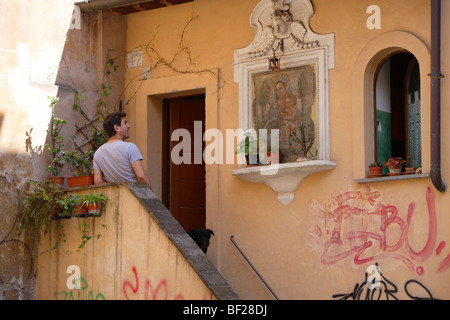 Mann steht vor dem Eingang eines Hauses im Stadtteil Trastevere, Rom, Italien, Europa Stockfoto