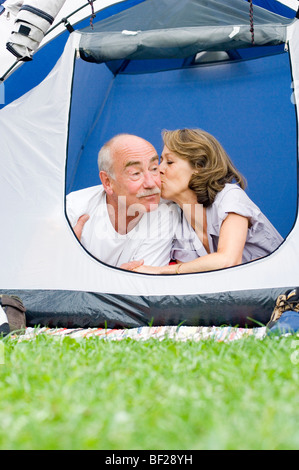 Älteres paar liegen in ihrem Zelt, Frau küssen Mann, Urlaub, Bayern, Deutschland Stockfoto