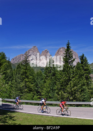 Radfahrer, die aufsteigende Sellajoch mit Langkofel massiv in den Hintergrund, Dolomiten, Italien Stockfoto