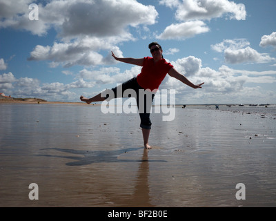 Eine Dame tanzt am Strand Stockfoto