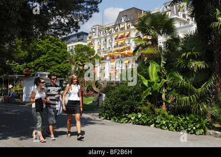 Junge Menschen zu Fuß entlang der Promenade, Grand Hotel Suisse im Hintergrund, Montreux, Kanton Waadt, Schweiz Stockfoto