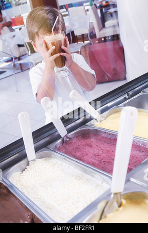 Junge mit einem Glas Schoko Milchshake in einer Eisdiele Stockfoto