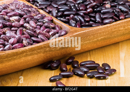 Kidney-Bohnen in hölzerne Schüssel und einige Bohnen auf Holztisch Stockfoto