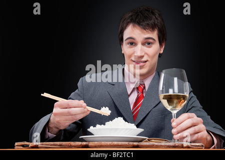 Porträt eines Geschäftsmannes, Reis mit Stäbchen essen Stockfoto