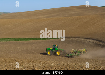 Ein John Deere Traktor und Luft Sämaschine Pflanzung Garbanzo Bohnen (Kichererbsen) in den sanften Hügeln der Palouse / Washington, USA. Stockfoto