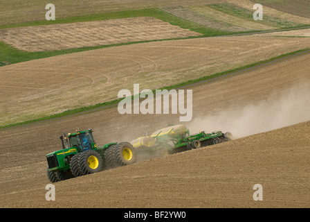 Ein John Deere Traktor und Luft Sämaschine Pflanzung Garbanzo Bohnen (Kichererbsen) in den sanften Hügeln der Palouse / Washington, USA. Stockfoto