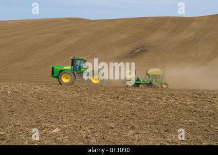 Ein John Deere Traktor und Luft Sämaschine Pflanzung Garbanzo Bohnen (Kichererbsen) in den sanften Hügeln der Palouse / Washington, USA. Stockfoto