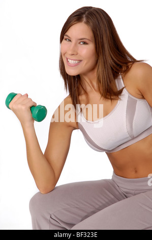 Attraktive, lächelnde Frau in Trainingskleidung mit Hand Gewicht. Stockfoto