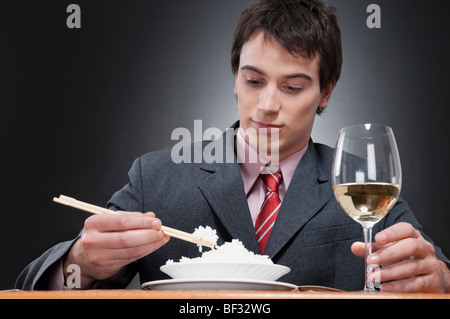 Nahaufnahme eines Geschäftsmannes, Reis mit Stäbchen essen Stockfoto