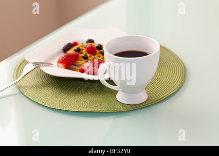 Erhöhte Ansicht von Erdbeeren mit Waffeln und einer Tasse Kaffee Stockfoto