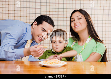 Mann, die Verfütterung von Pommes frites an seinen Sohn Stockfoto