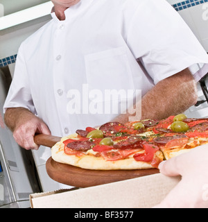 Zwei Köche, die Pizza in der Küche vorbereiten Stockfoto