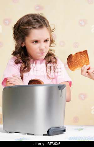 Geben ihrer Tochter einen verbrannten Toast Frau Stockfoto