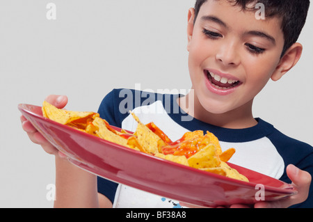 Nahaufnahme eines jungen hält eine Platte mit nachos Stockfoto