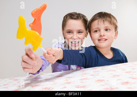 Porträt eines jungen und ein Mädchen halten Tier geformt Lutscher Stockfoto