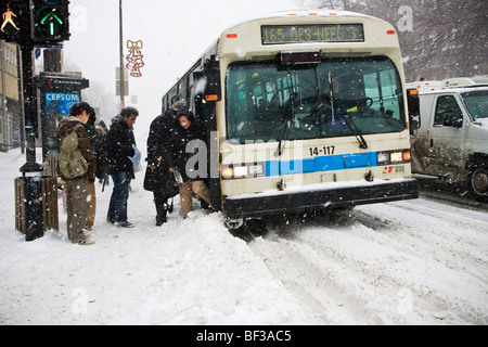 Menschen, die einsteigen in eines Bus bei einem Wintersturm Schnee auf dem Plateau in Montreal. Stockfoto