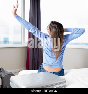 Frau erstreckt sich auf ihrem Bett Stockfoto