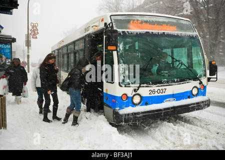 Menschen, die einsteigen in eines Bus bei einem Wintersturm Schnee auf dem Plateau in Montreal. Stockfoto