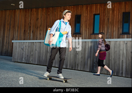 Junger Mann auf Skateboard mit shopping Stockfoto