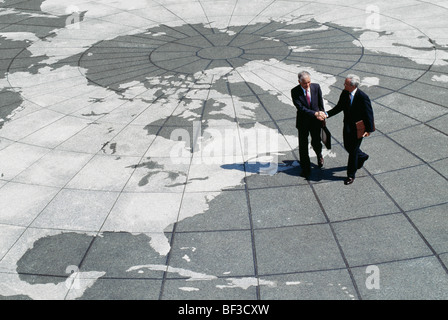 Geschäftsleute Händeschütteln auf Karte der Welt Stockfoto