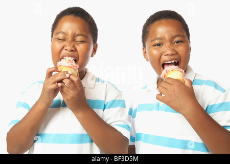 Junge afrikanische Zwillingsbrüder Cupcakes Essen Stockfoto