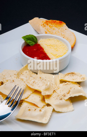 Erhöhte Ansicht von Ravioli serviert mit Tomatensauce und geriebenem Käse Stockfoto