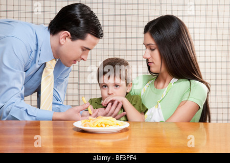 Mann, die Verfütterung von Pommes frites an seinen Sohn Stockfoto