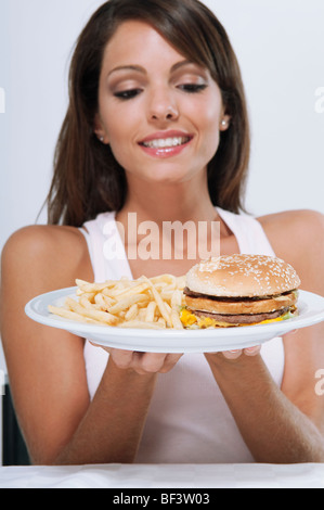 Frau mit einer Platte aus Hamburger und Pommes frites Stockfoto