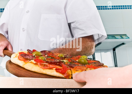 Zwei Köche, die Pizza in der Küche vorbereiten Stockfoto