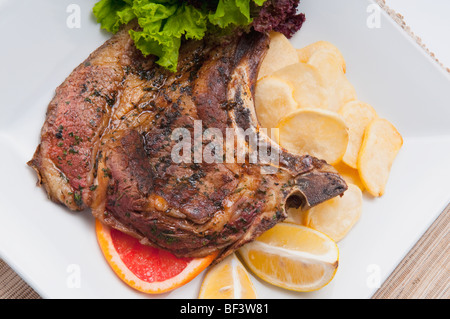 Erhöhte Ansicht der Schweinekoteletts mit Bratkartoffeln serviert Stockfoto