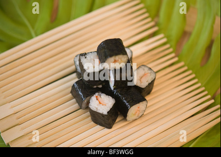 Nahaufnahme von Maki Sushi auf Essstäbchen Stockfoto