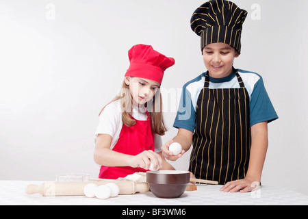 Junge Vorbereitung einen Kuchen mit seiner Schwester Stockfoto