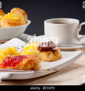 Nahaufnahme des dänisches Gebäck mit einer Tasse schwarzen Kaffee serviert Stockfoto