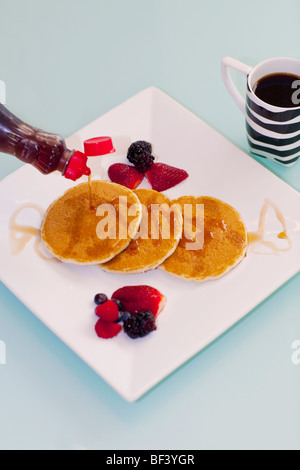 Sirup gegossen auf Pfannkuchen Stockfoto