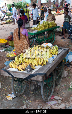 Indische Frau verkaufen Bananen aus einem Barrow am Markttag. Puttaparthi, Andhra Pradesh, Indien Stockfoto