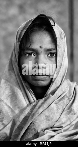 Arme indische Mädchen in einem schmutzigen Laken gehüllt. Monochrom Stockfoto