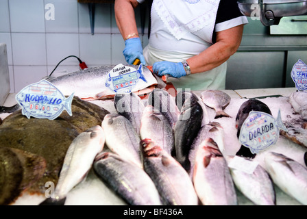 Fischhändler schneidet Lachs hinter Steinbutt (links) und Bass zum Verkauf an Fisch stall auf dem zentralen Markt Mercado Central Valencia Stockfoto