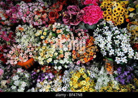 Trauben von bunten farbenfrohen gefälschte künstlichen Plastikblumen blüht auf Verkaufsmarkt unter freiem Himmel ho Chi Minh Stadt Vietnam Asien Stockfoto