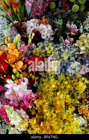 Trauben von bunten farbenfrohen gefälschte künstlichen Plastikblumen blüht auf Verkaufsmarkt unter freiem Himmel ho Chi Minh Stadt Vietnam Asien Stockfoto