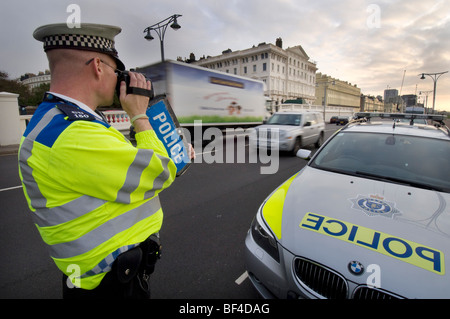 Ein Polizist mit einem handheld Laserkamera auf einer Stadt-Straße, Geschwindigkeitsüberschreitungen fangen Autofahrer Stockfoto