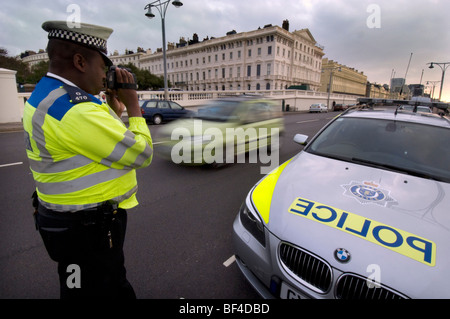 Ein schwarzer Polizist mit einem Laserkamera, Geschwindigkeitsüberschreitungen fangen Autofahrer Stockfoto