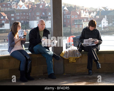 Eine dreiköpfige Familie, wegnehmen Mann Frau und Tochter Essen Fish &amp; Chips im Elster-Café unter dem Musikpavillon in Whitby Stockfoto