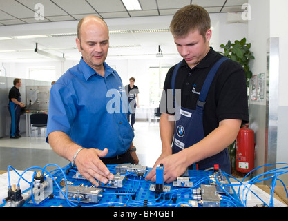Meister, Andreas Fischer, eine elektrische Schaltung, Lehrling in der BMW-Ausbildungszentrum für Kfz-Mechatroniker zu erklären Stockfoto
